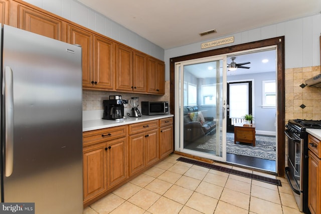 kitchen featuring light tile patterned floors, visible vents, decorative backsplash, appliances with stainless steel finishes, and light countertops