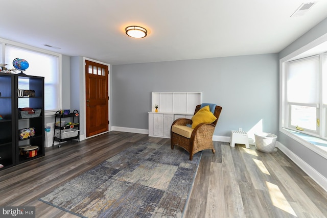 sitting room featuring visible vents, baseboards, and wood finished floors