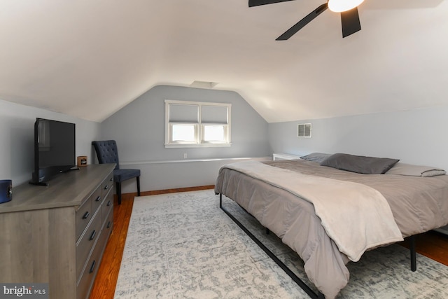 bedroom with lofted ceiling, visible vents, ceiling fan, and wood finished floors