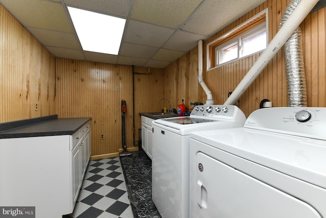 laundry room featuring washer and dryer, cabinet space, a sink, and light floors