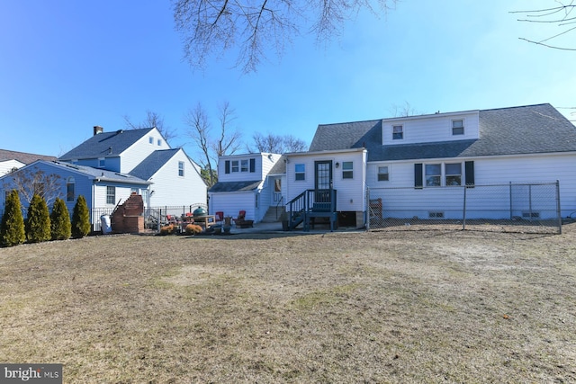 view of front of house featuring a front yard, fence, and roof with shingles