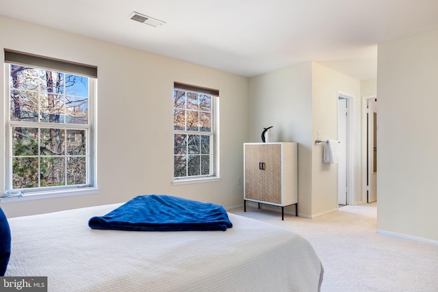 bedroom featuring visible vents, light colored carpet, and baseboards