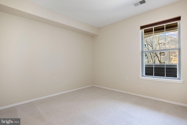 carpeted spare room with baseboards and visible vents