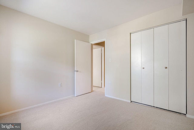 unfurnished bedroom with a closet, baseboards, and carpet flooring