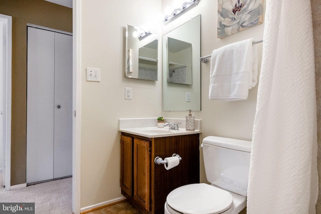 bathroom with vanity, toilet, and baseboards