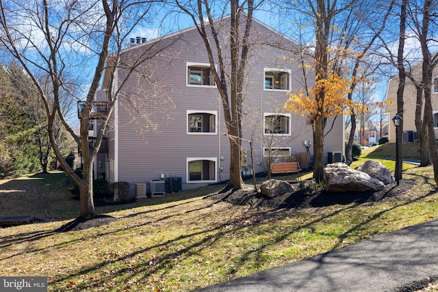 exterior space featuring cooling unit and a lawn