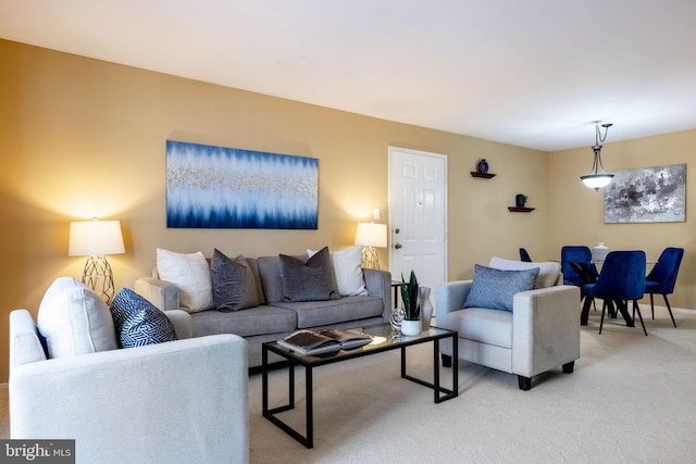 living area featuring light carpet and baseboards