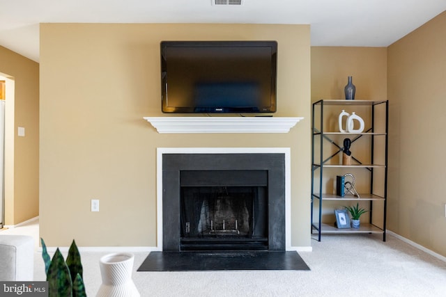 details featuring a fireplace with flush hearth, baseboards, visible vents, and carpet floors