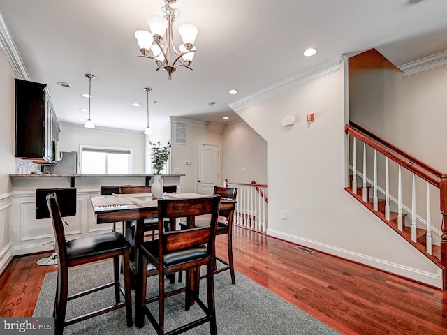 dining area featuring visible vents, ornamental molding, a chandelier, and dark wood-type flooring