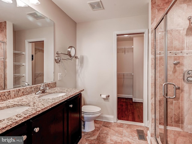 full bathroom with a stall shower, a walk in closet, and visible vents