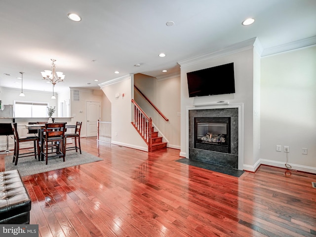 living room with baseboards, a tiled fireplace, wood-type flooring, stairs, and recessed lighting