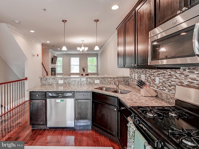 kitchen featuring tasteful backsplash, a peninsula, stainless steel appliances, dark brown cabinets, and a sink