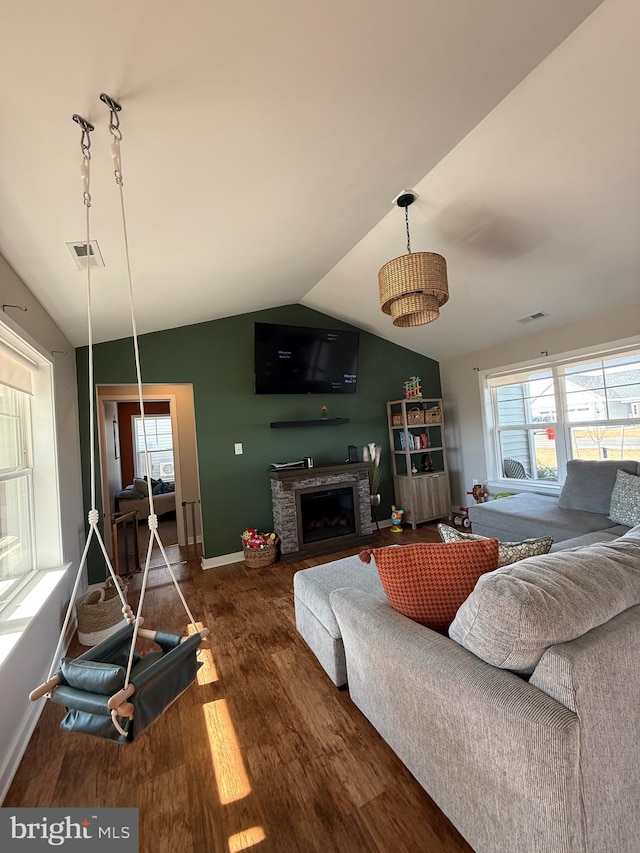 living area with visible vents, plenty of natural light, lofted ceiling, and wood finished floors