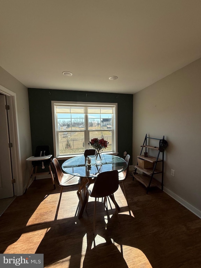 dining area with baseboards and wood finished floors