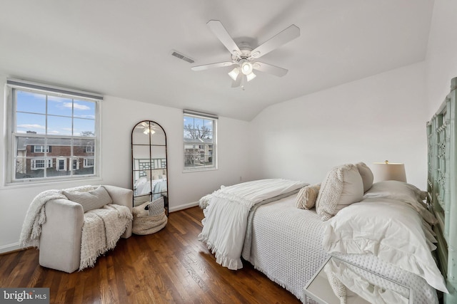 bedroom with lofted ceiling, multiple windows, visible vents, and dark wood-style flooring