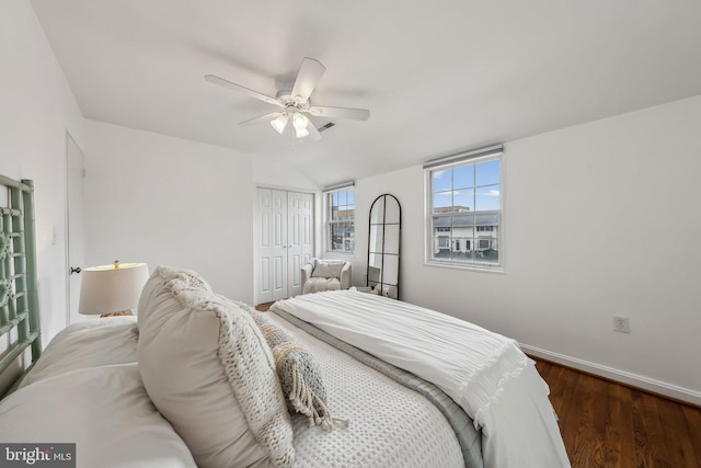 bedroom with a closet, wood finished floors, a ceiling fan, and baseboards