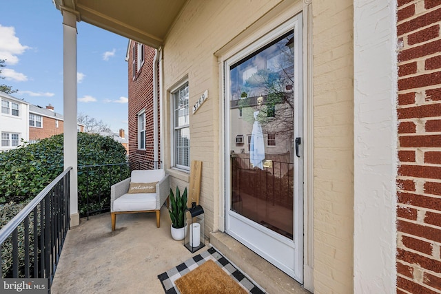 exterior space featuring brick siding and a balcony