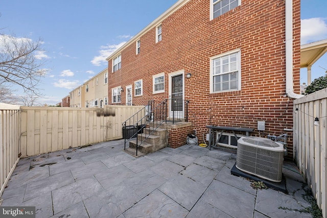 view of patio / terrace with a fenced backyard and central air condition unit