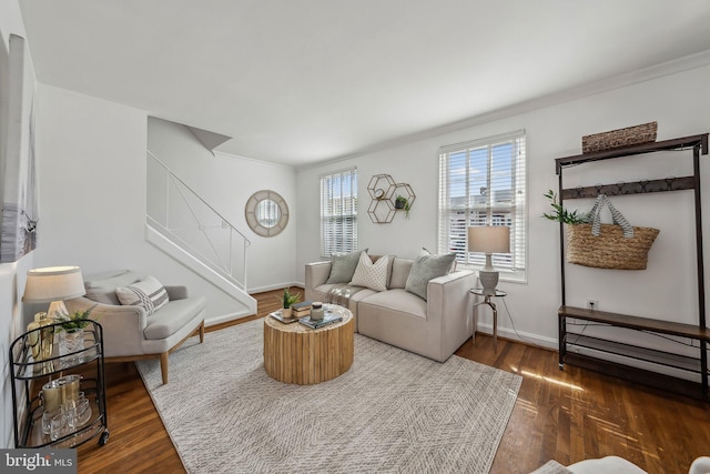 living area with ornamental molding, stairway, baseboards, and wood finished floors