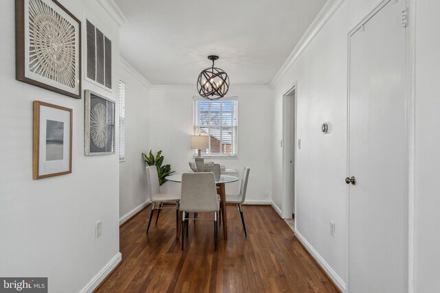 dining area featuring dark wood-style flooring, crown molding, visible vents, an inviting chandelier, and baseboards