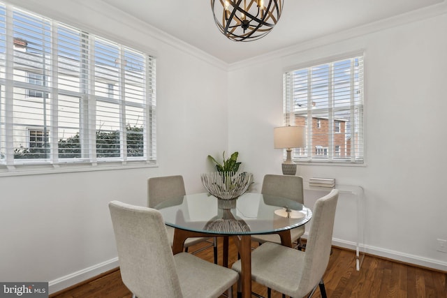 dining area featuring baseboards, a notable chandelier, wood finished floors, and crown molding