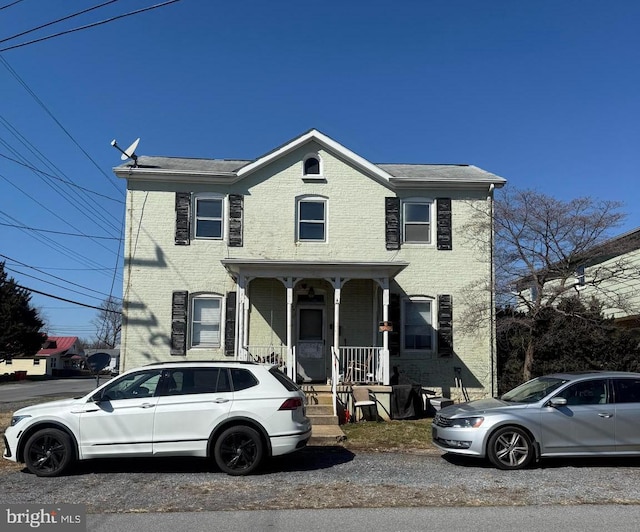 view of front of property featuring brick siding and a porch