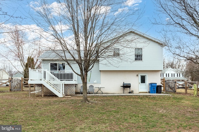 rear view of house featuring a gate, a lawn, and fence