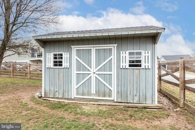 view of shed featuring fence