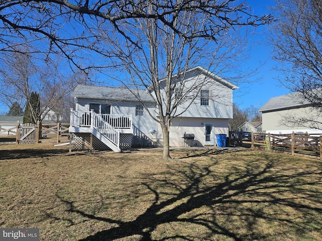 rear view of house with a lawn, a fenced backyard, and a gate