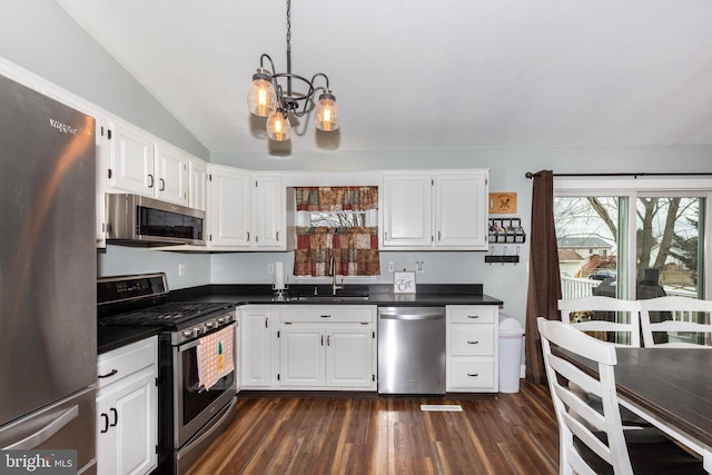 kitchen featuring dark countertops, white cabinetry, appliances with stainless steel finishes, and a sink