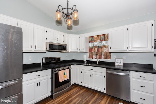 kitchen with stainless steel appliances, dark countertops, and a sink