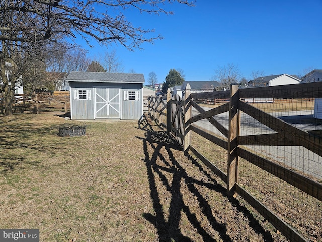 view of yard featuring a storage shed, an outdoor structure, and fence