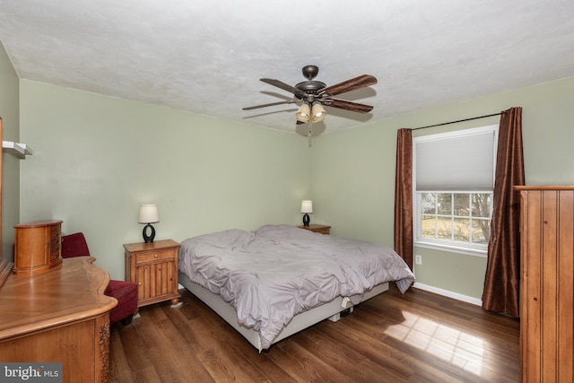 bedroom featuring ceiling fan, dark wood-style flooring, and baseboards