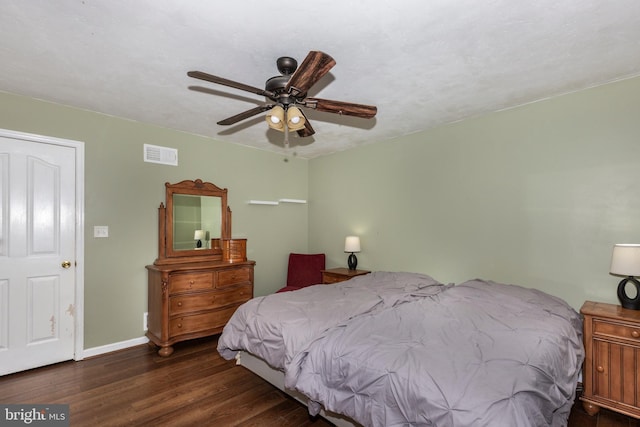 bedroom featuring ceiling fan, wood finished floors, visible vents, and baseboards