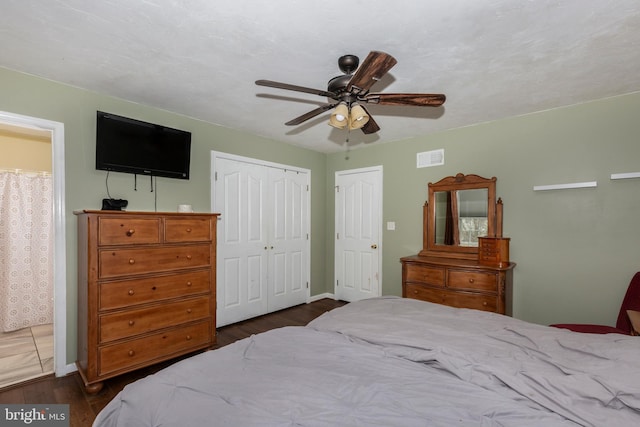 bedroom featuring dark wood-style flooring, a closet, visible vents, and a ceiling fan