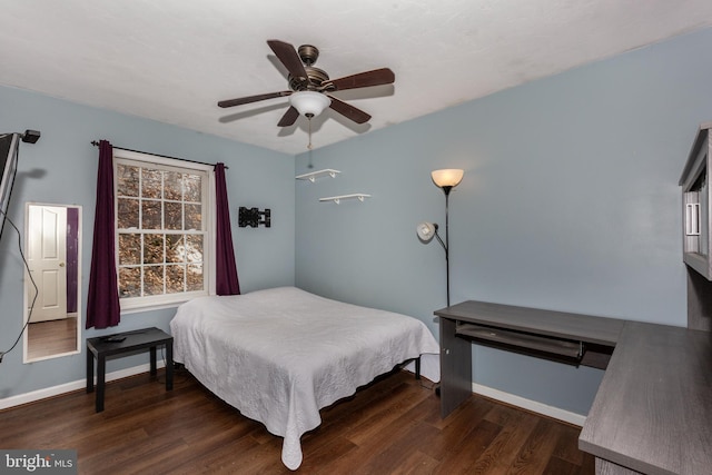 bedroom with dark wood finished floors, a ceiling fan, and baseboards