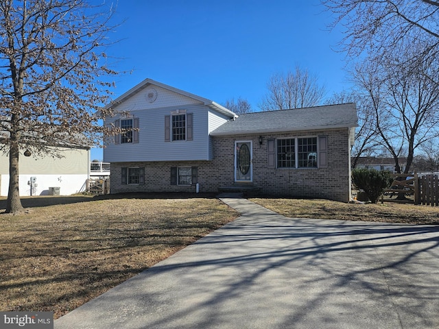 split level home featuring brick siding and a front lawn