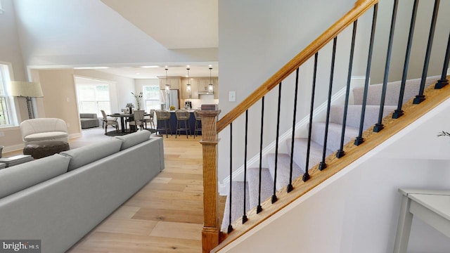 living area with light wood finished floors and stairway