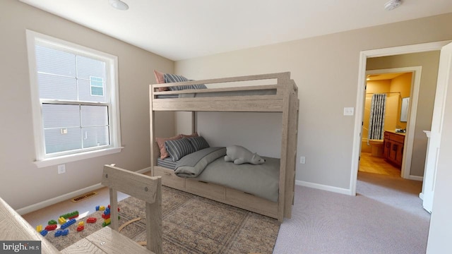 bedroom featuring baseboards, visible vents, and light colored carpet