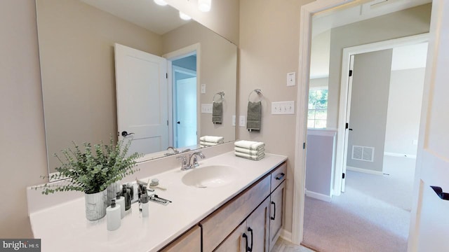 bathroom with vanity, visible vents, and baseboards