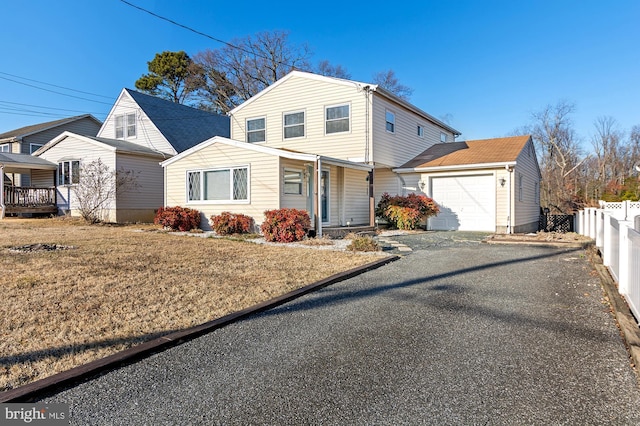 view of front of property featuring aphalt driveway, a front lawn, an attached garage, and fence