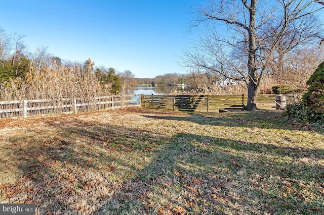 view of yard featuring a water view and fence