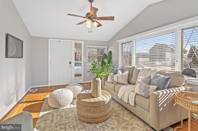 living area with vaulted ceiling, ceiling fan, wood finished floors, and baseboards