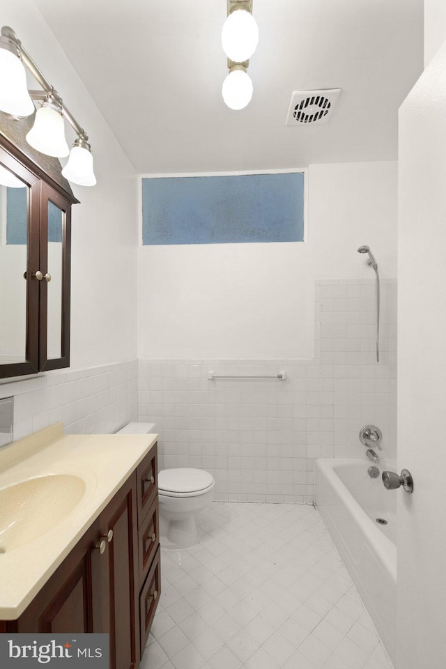 bathroom featuring tile walls, visible vents, vanity, and toilet