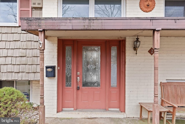 view of exterior entry with brick siding