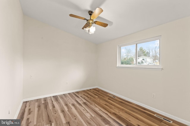 unfurnished room with light wood-style floors, baseboards, visible vents, and ceiling fan