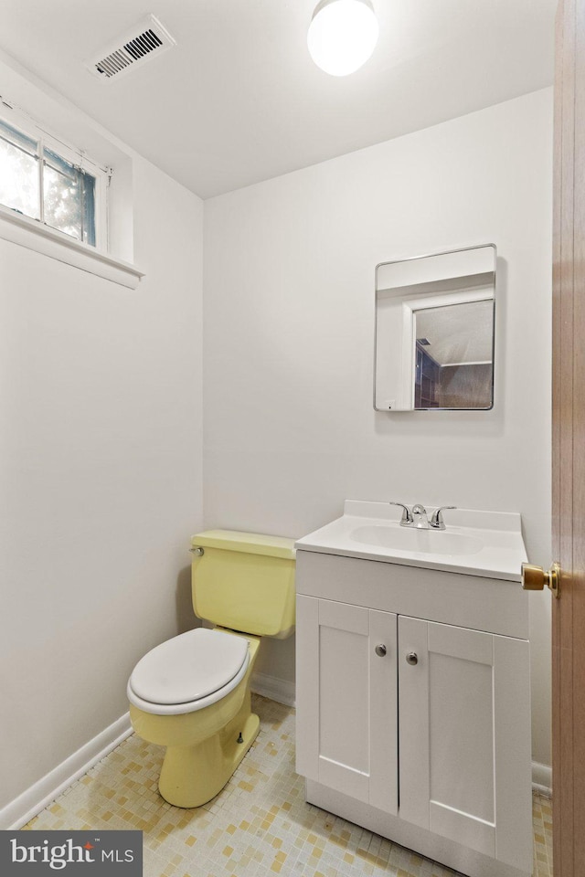 bathroom featuring baseboards, visible vents, vanity, and toilet