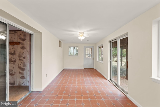 unfurnished sunroom featuring ceiling fan