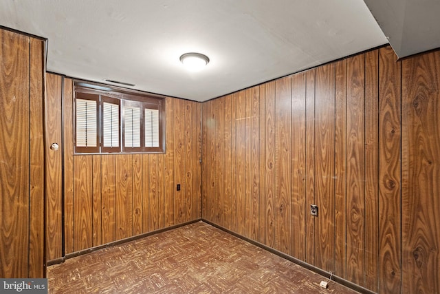 spare room with wooden walls and baseboards