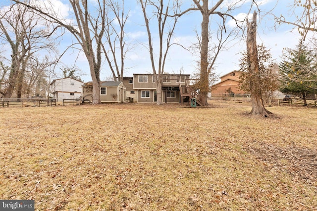 rear view of house featuring a yard, stairs, fence, and a wooden deck